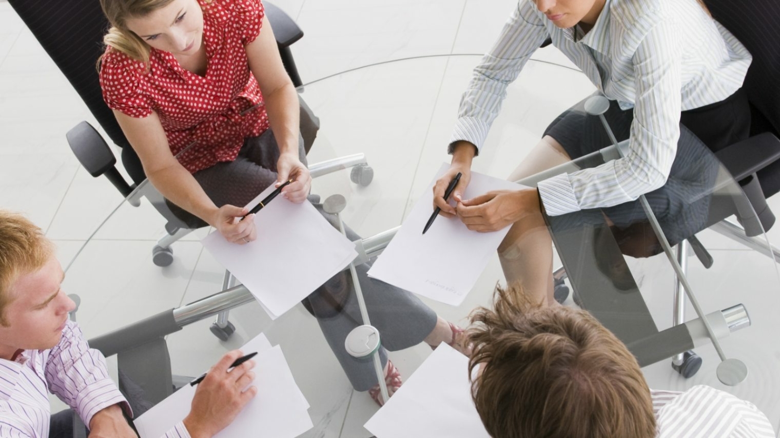 four-businesspeople-in-a-boardroom-with-paperwork-PC4V8H4@2x.jpg