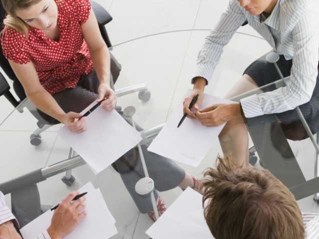 four-businesspeople-in-a-boardroom-with-paperwork-PC4V8H4@2x.jpg